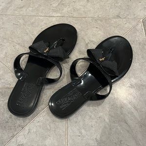 Salvatore Ferragamo women’s rubber bow sandal. Black with gold logo. Size 7.